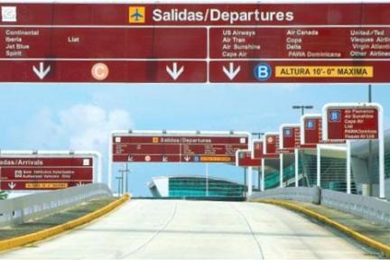 Airport road with signs for departures and arrivals, multiple airline logos visible.