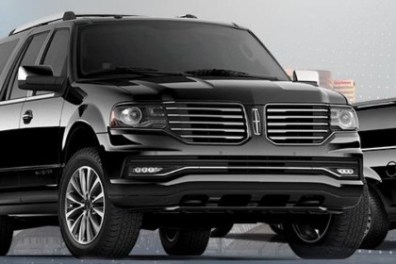 Black luxury SUV with chrome details on cityscape background.